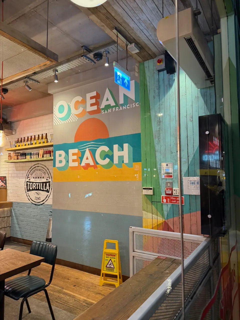 A mural in a burrito store reading "Ocean Beach, San Francisco", with a painting of a sunny beach