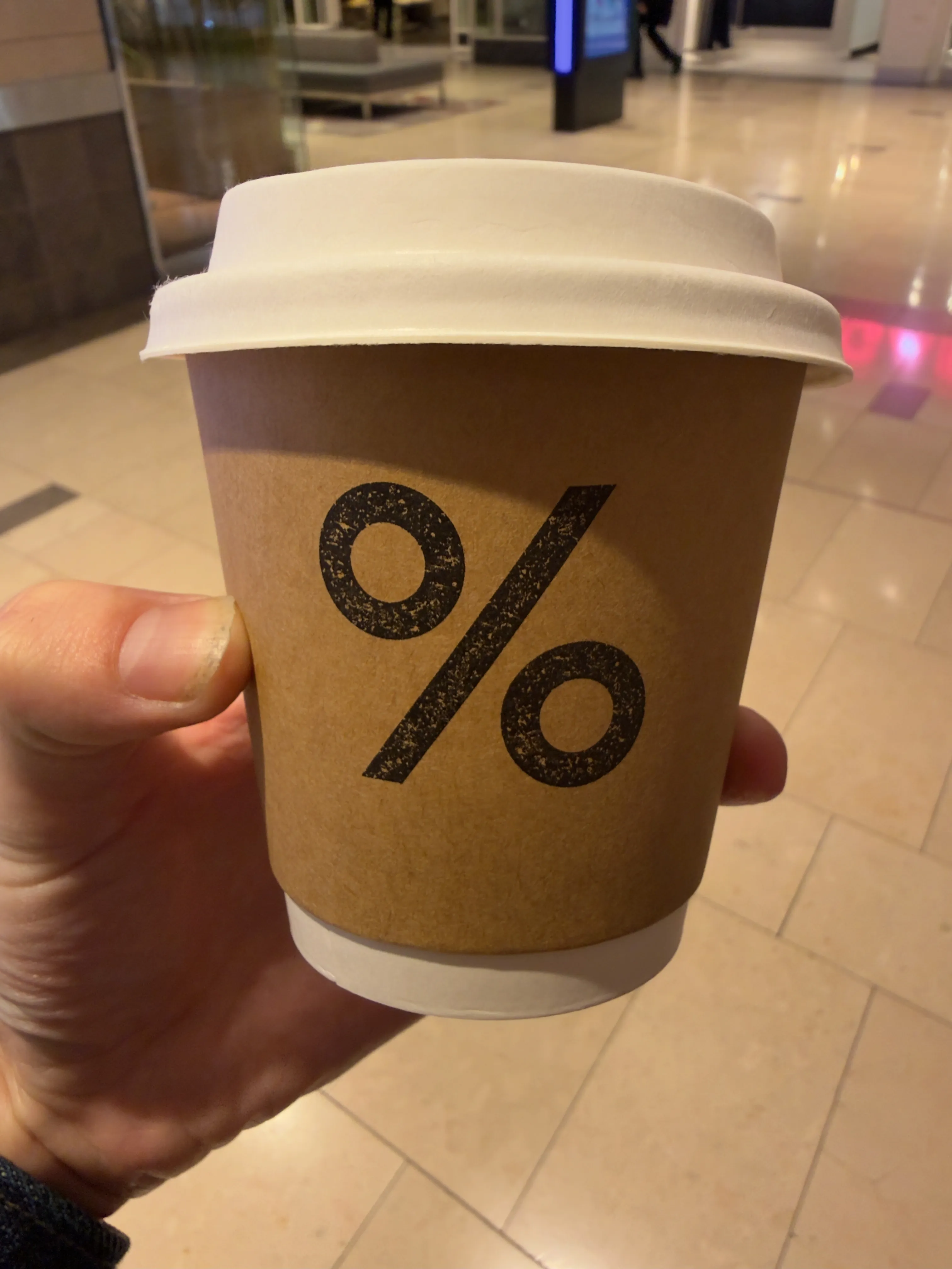 Front side of a coffee cup from % Arabica, showing their label Front side of a coffee cup from % Arabica, showing their label