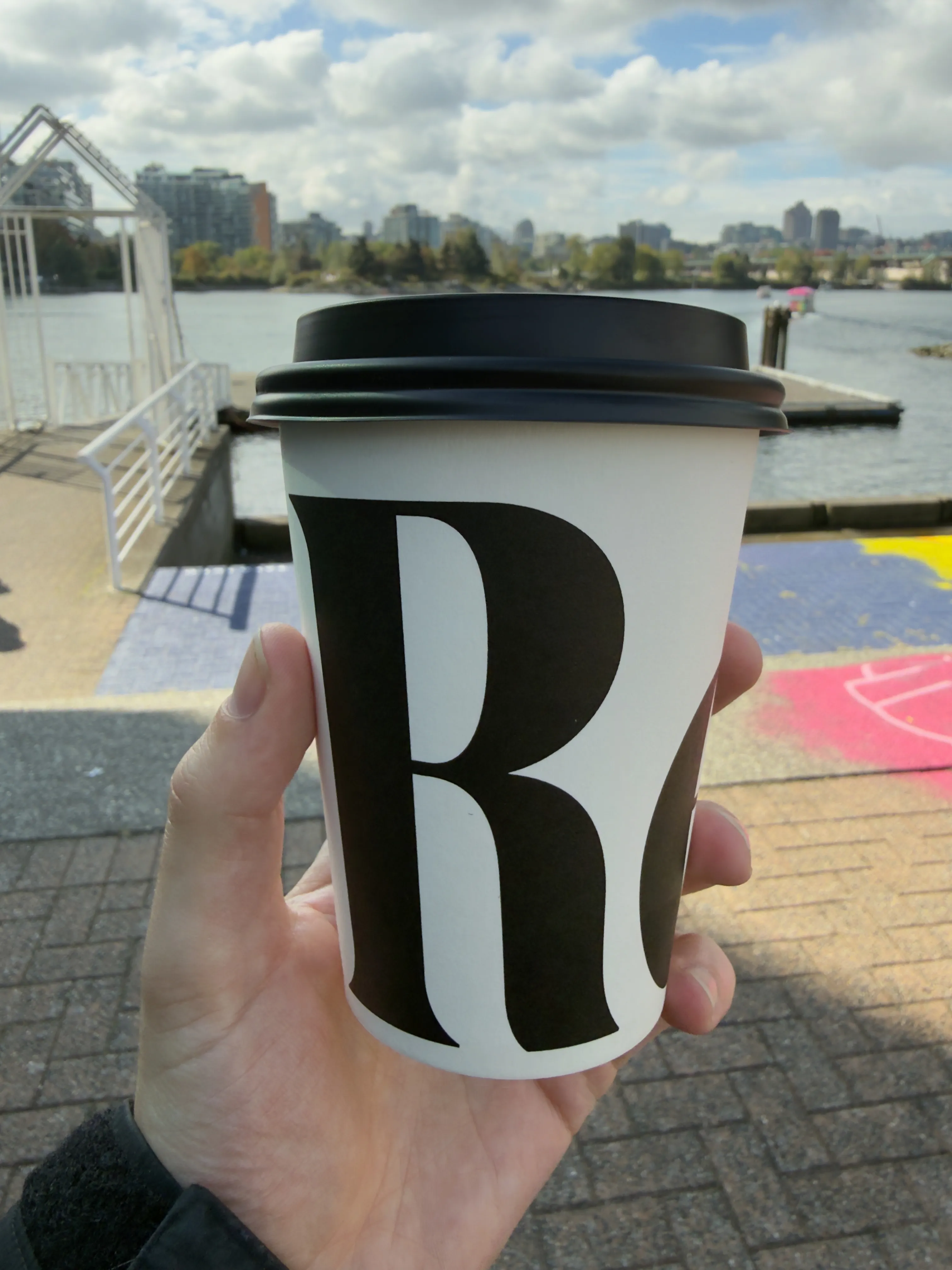 Front side of a coffee cup from Revolver, showing the R of their logo Front side of a coffee cup from Revolver, showing the R of their logo