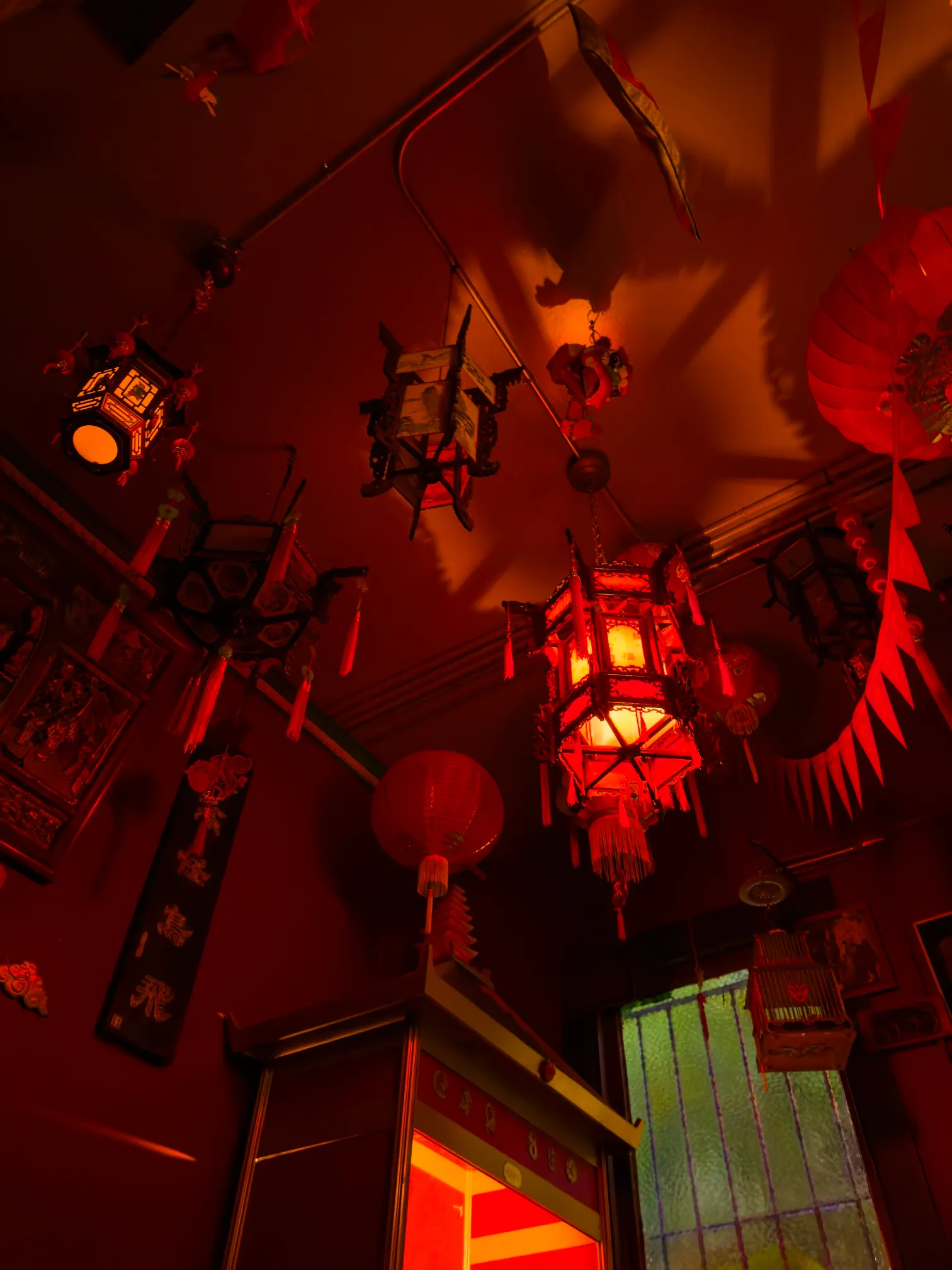 A set of Chinese lanterns hanging from a red-painted ceiling