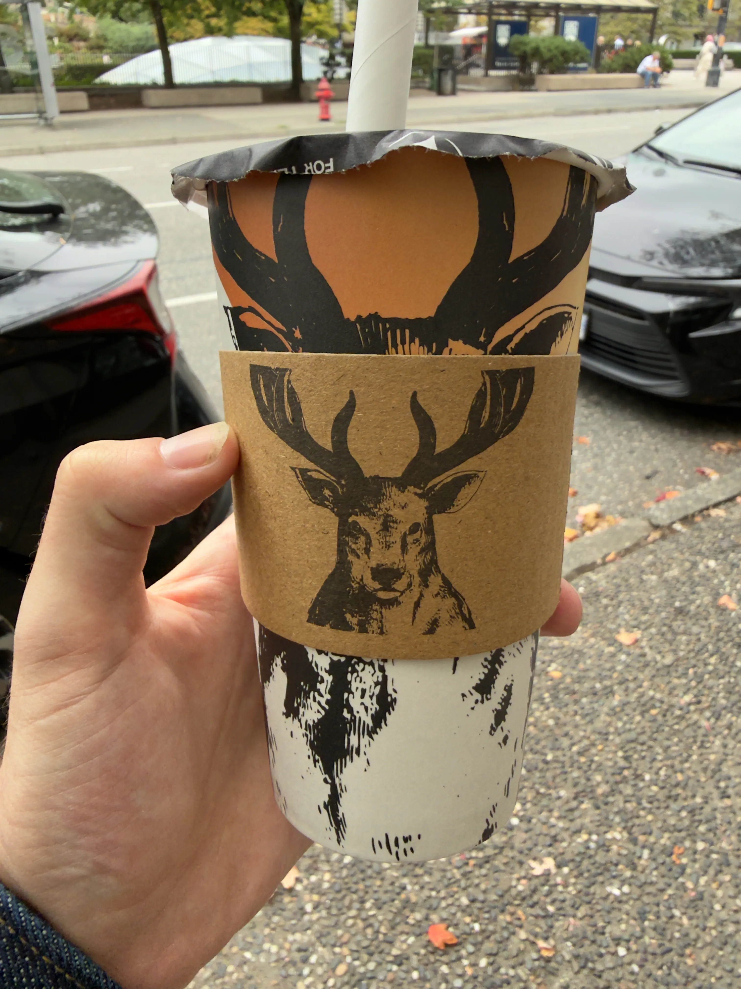 Front side of a tea cup from The Alley, showing their deer logo Front side of a tea cup from The Alley, showing their deer logo