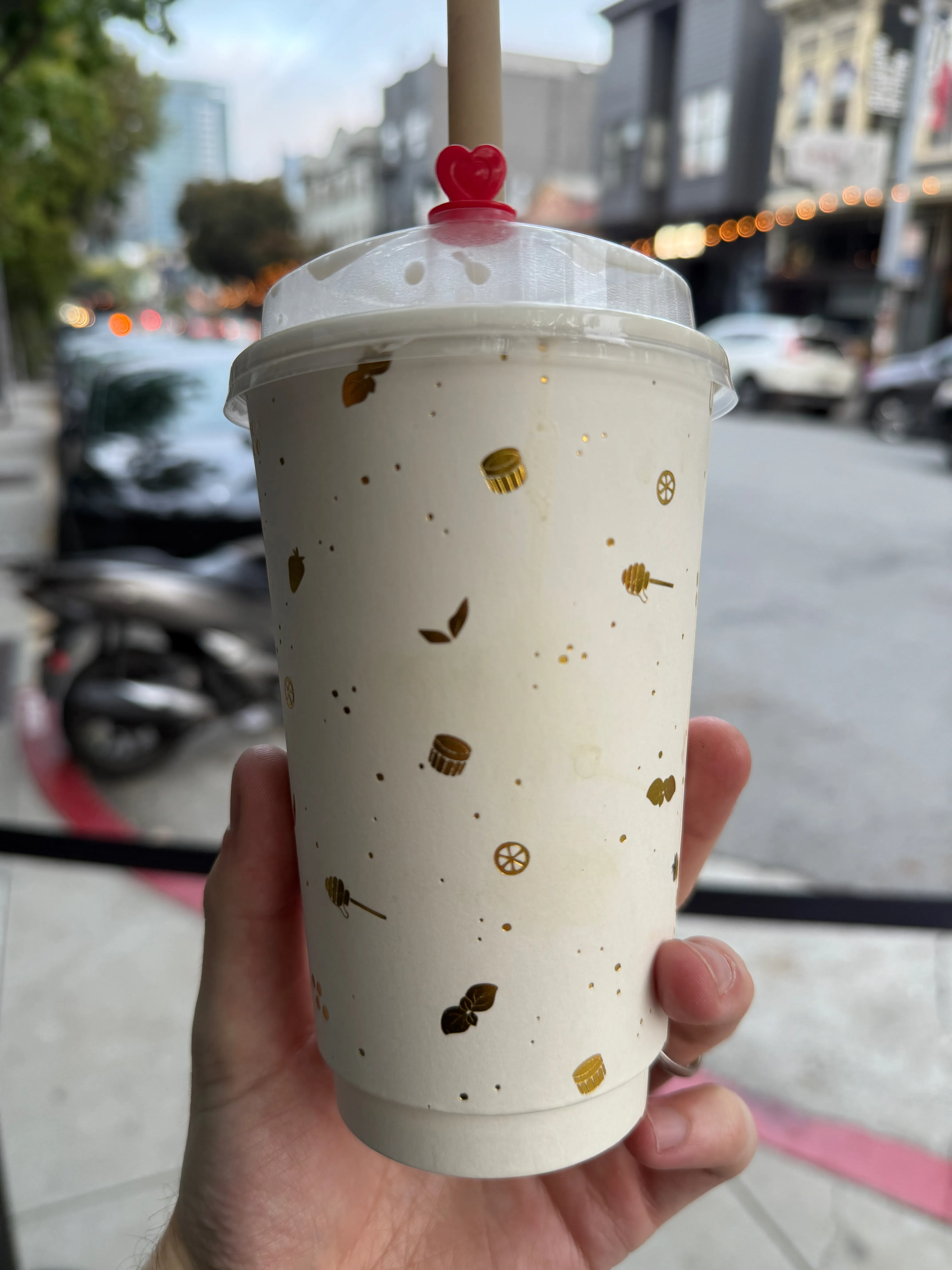 Back side of a tea cup from Urban Ritual, featuring stylized tea leaves and honey spoons